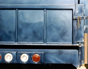 Oil painting of the rear of a vintage blue truck with round tail lights